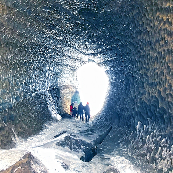 People walking through an Ice tunnel in Mýrdalsjökull glacier